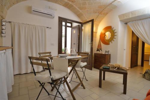 a dining room with a table and chairs in a room at Palazzo Kapece in Monopoli