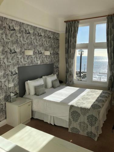a bedroom with a large bed with a view of the ocean at Bedford Hotel in Sidmouth