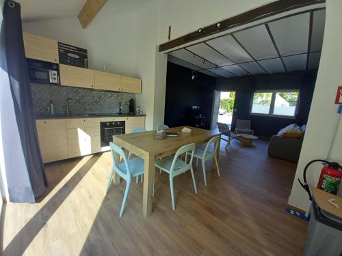eine Küche und ein Esszimmer mit einem Tisch und Stühlen in der Unterkunft Pourquoi pas Au Canard in Jurbise