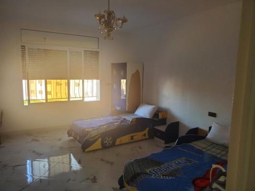 um quarto com 2 camas e um lustre em My house 3 em Nador