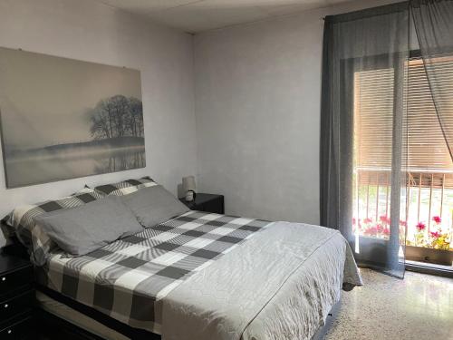 a bedroom with a checkered bed and a window at Apartamento entero con terraza en el centro de Rubí in Rubí