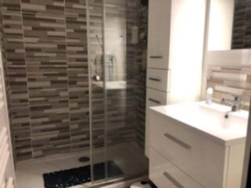 a bathroom with a glass shower with a sink and a sink at appartement en résidence vue mer , piscine… in Six-Fours-les-Plages