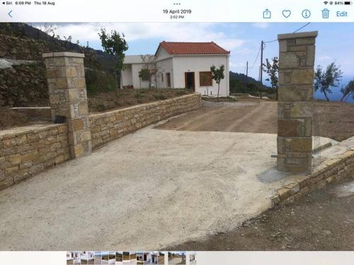 a stone retaining wall in front of a house at Manolates 360 views sea and mountains in Valeontádes