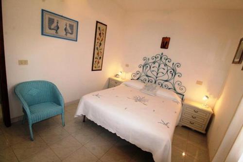 a bedroom with a white bed and a blue chair at La Banchina Residence in Cannigione