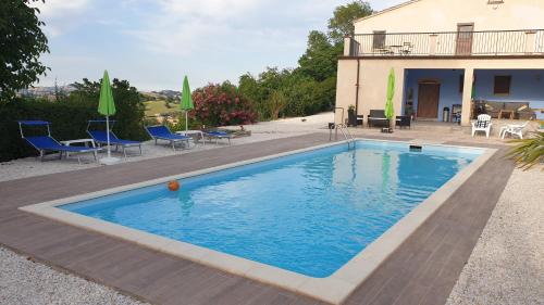 a swimming pool in front of a house at Casale di Maro in Monte Giberto