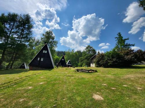 a group of small buildings in a grass field at Toska rekreační středisko in Prostřední Bečva