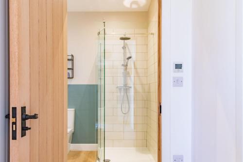 baño con ducha y puerta de cristal en Lacton Manor Barns by Bloom Stays, en Ashford