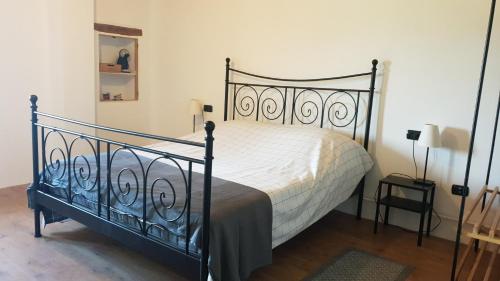 a bedroom with a black bed with a white comforter at Casale di Maro in Monte Giberto
