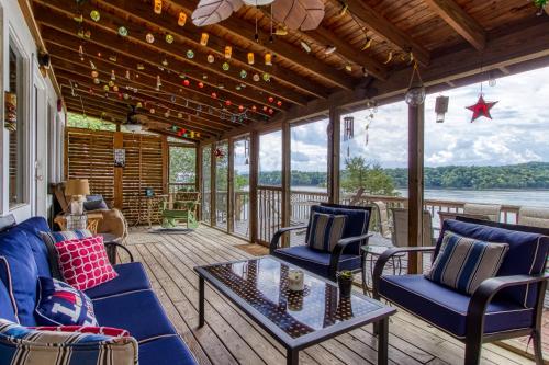 a screened in porch with chairs and a table at Live Luv Lake, Hot Tub, Private Boat Dock, WIFI,685 FREE tickets each paid day in Dandridge