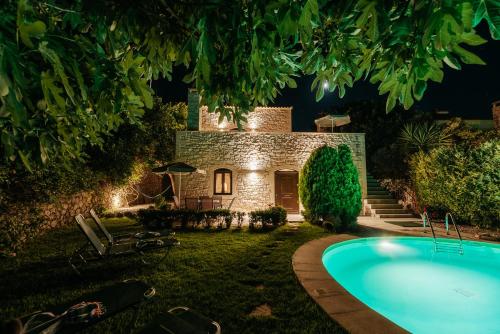 a house with a pool in the yard at night at Villa Olympia - Villa Erato in Prinés