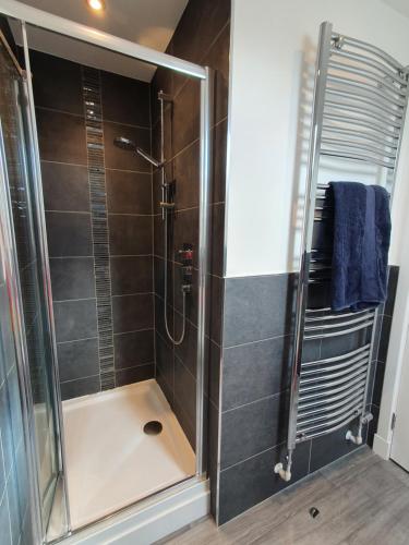 a shower with a glass door in a bathroom at The White House in Elgin
