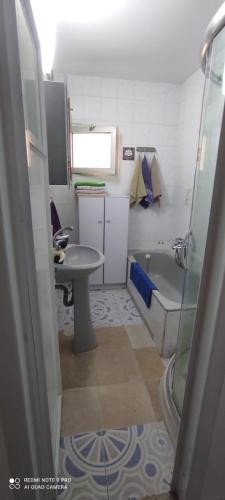 a small bathroom with a sink and a tub at Apartments Haagna in Ashdod