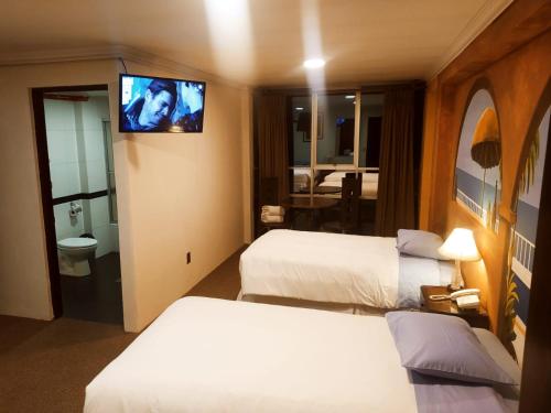 a hotel room with two beds and a flat screen tv at Terraza Hotel in La Paz