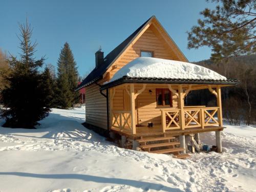 a log cabin with snow on the ground at Markowa Chata in Cisna