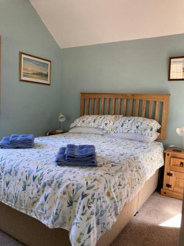 Un dormitorio con una cama con toallas azules. en The Old Barn Annexe, en West Runton
