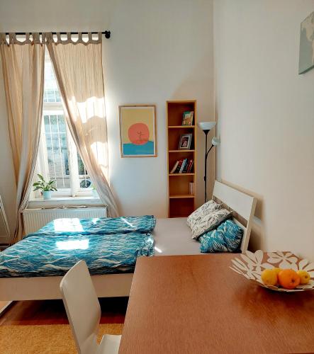 Habitación con cama, mesa y ventana en Cozy studio in Vinohrady en Praga
