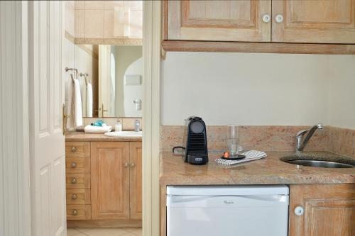 una cocina con fregadero y un teléfono en la encimera en Andros Homes Sea Side Apartment & Studio, en Gavrion