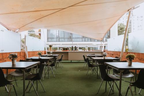 an empty dining room with tables and chairs at Travelers Orange Suites in Medellín