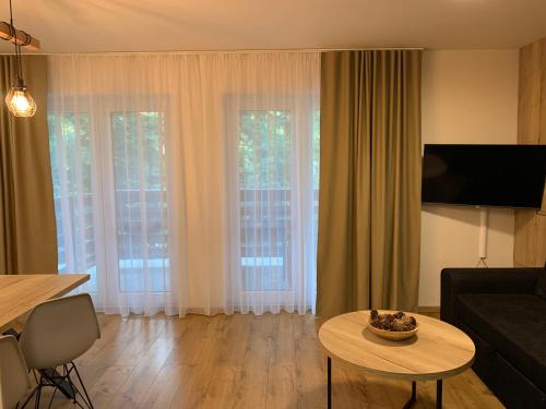 a living room with a table and some windows at Apartmány Valča in Valča