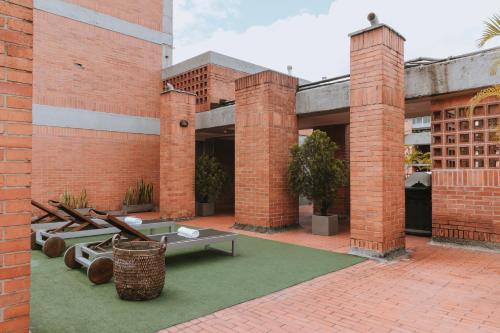 a brick building with a courtyard with picnic tables at Travelers Orange Suites in Medellín