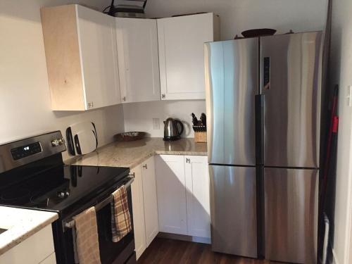 a kitchen with a stainless steel refrigerator and white cabinets at 1620 - 5-Room Apt. with Pool & Gardens , Near Downtown in St. Petersburg
