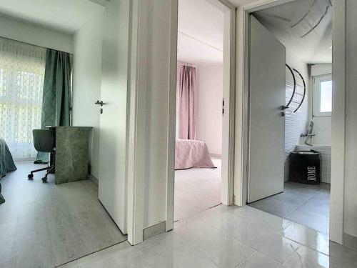 a white room with a bed and a mirror at La villa petite Camargue in Saint-Louis