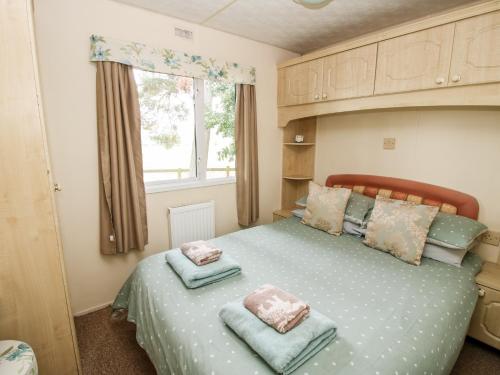 a bedroom with a bed with two pillows on it at 6 Old Orchard in Much Wenlock