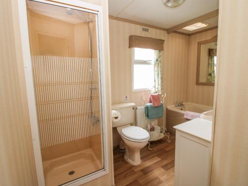a small bathroom with a toilet and a sink at 8 Old Orchard in Much Wenlock