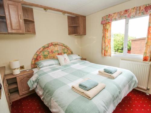 a bedroom with a large bed with towels on it at 10 Old Orchard in Much Wenlock