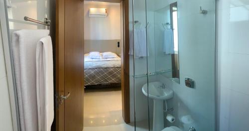 a bathroom with a shower and a toilet and a sink at Hotel Villa Inácia in Vacaria