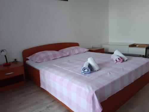 1 dormitorio con 1 cama con sábanas rosas y blancas en Apartments Davor Ceko, en Jesenice