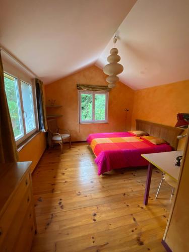 une chambre avec un lit et un parquet dans l'établissement Maison située au Val de Baubère, petite vallée à coté du village de Seix, à Seix