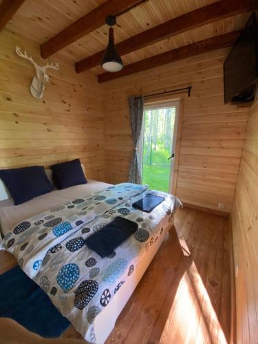 - une chambre avec un lit dans une cabane en rondins dans l'établissement Pod Brzozą, à Łuka