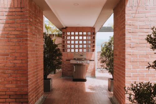 an outdoor patio with an outdoor oven in a brick building at Travelers Orange Suites in Medellín