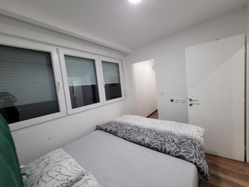 a bedroom with a bed and two windows at Stan m&s, Boulevard-centar grada in Banja Luka