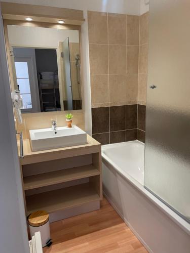 a bathroom with a sink and a tub and a mirror at Appt 4 a 6 pers aux pieds des pistes Les terrasses du soleil d or résidence avec piscine in Les Orres