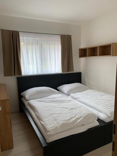a bed with two white pillows on top of it at Apartmány Valča in Valča