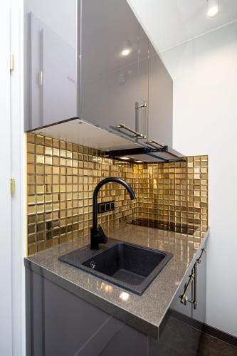 a kitchen with a sink and aaucet at Domki Przy Tężni in Karwia