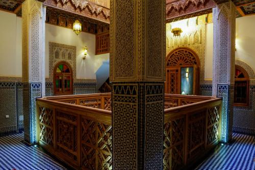 mezquita con escalera y habitación con techos ornamentados. en Riad Al Fassia Palace en Fez