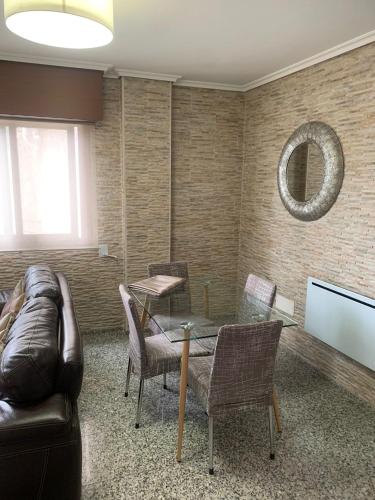 a living room with a glass table and a leather couch at Estudio tipo Loft en el centro de Mugardos in Mugardos