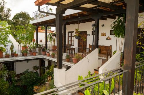 une maison avec des plantes en pot sur la terrasse couverte à l'avant dans l'établissement Hotel La Villa Serena, à Antigua Guatemala