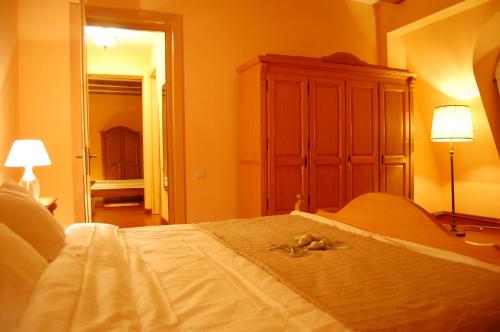 a bedroom with a large white bed with a dresser at Bucharest Boutique Accommodation by Hotels in Bucharest