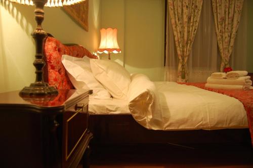a bedroom with a bed and a lamp on a dresser at Bucharest Boutique Accommodation by Hotels in Bucharest