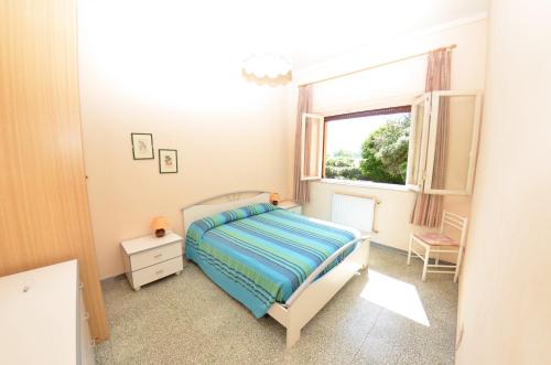 niewielka sypialnia z łóżkiem i oknem w obiekcie Villa Elisa w mieście Bientina