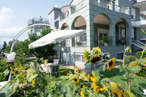 a building with a yard with sunflowers at Apollon house in Volos
