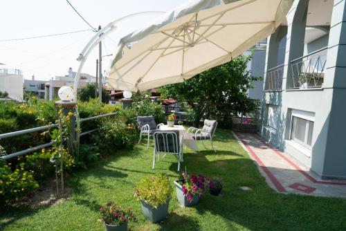 a patio with an umbrella and a table and chairs at Apollon house in Volos