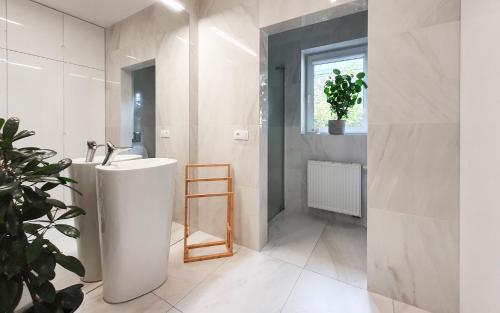 a bathroom with a white tub and a sink at Holimo Hotel in Stronie Śląskie