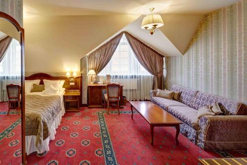 a hotel room with a couch and a bed at Hotel Atlas Deluxe in Lviv