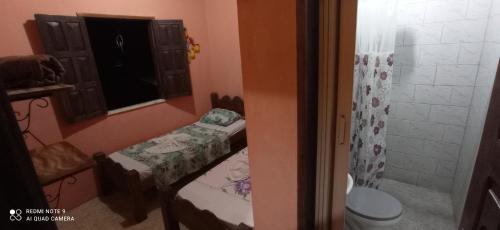 a bathroom with two twin beds and a shower at Pousada Labarca in Cachoeira