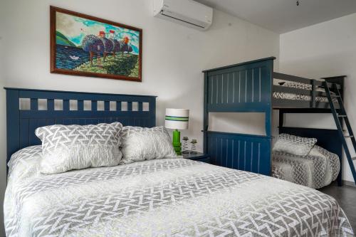 ein Schlafzimmer mit einem Bett und einem Etagenbett in der Unterkunft Costa del Sol 66 in Esterillos
